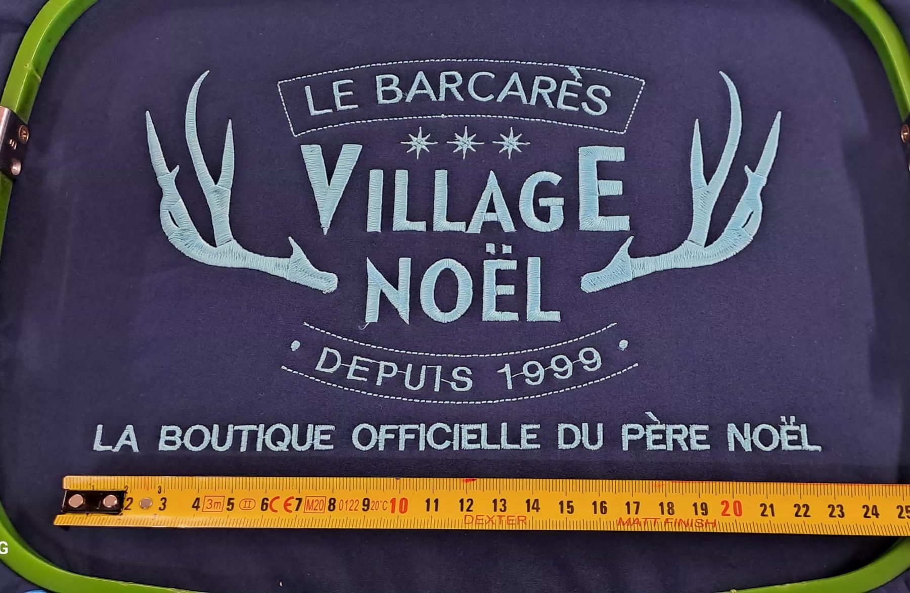 Broderie d'un logo contrôlée à la règle avant validation